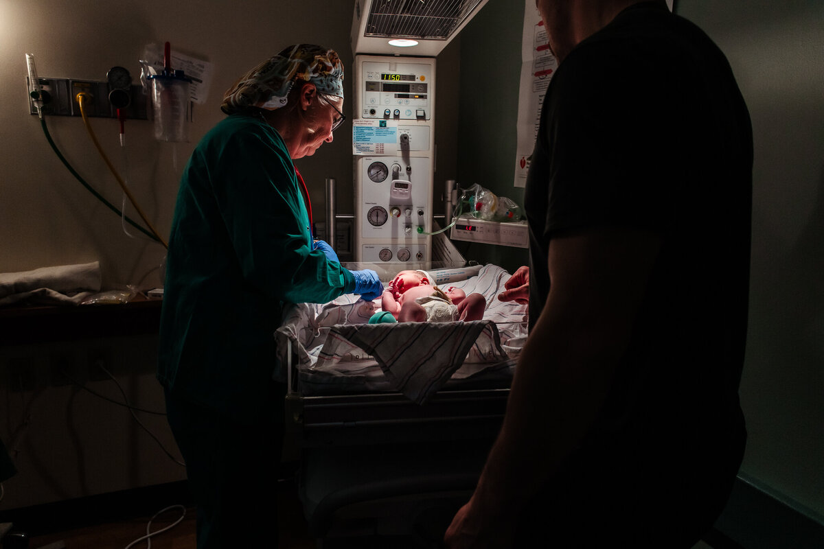 A baby is laying on a warmer receiving his first checks after being born at Memorial Hospital in Modesto. His mother was supported by Modesto Doula Shayna Cox. 