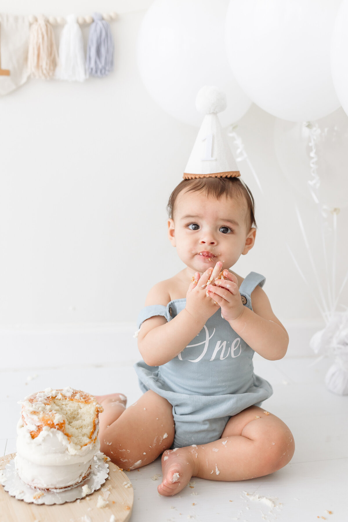 baby eating cake sitting on floor