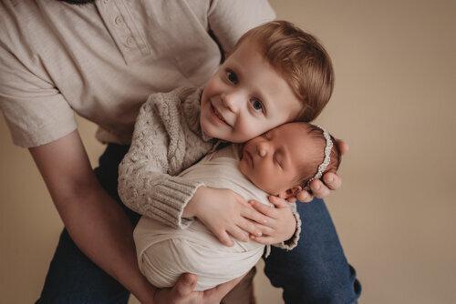 Baby girl sleeping for newborn portrait session with Atlanta Georgia newborn photographer snuggled up in a swaddle posing with her family