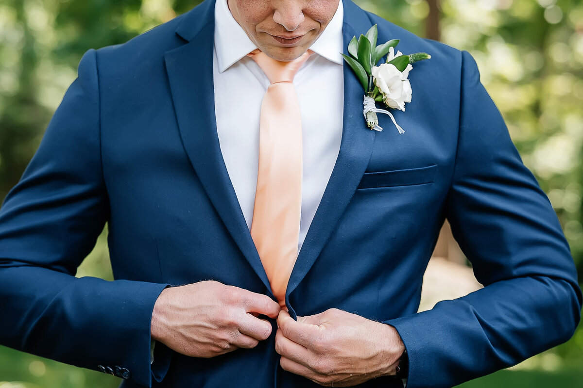 Groom-buttoning-suit-pebble-beach-the-lodge