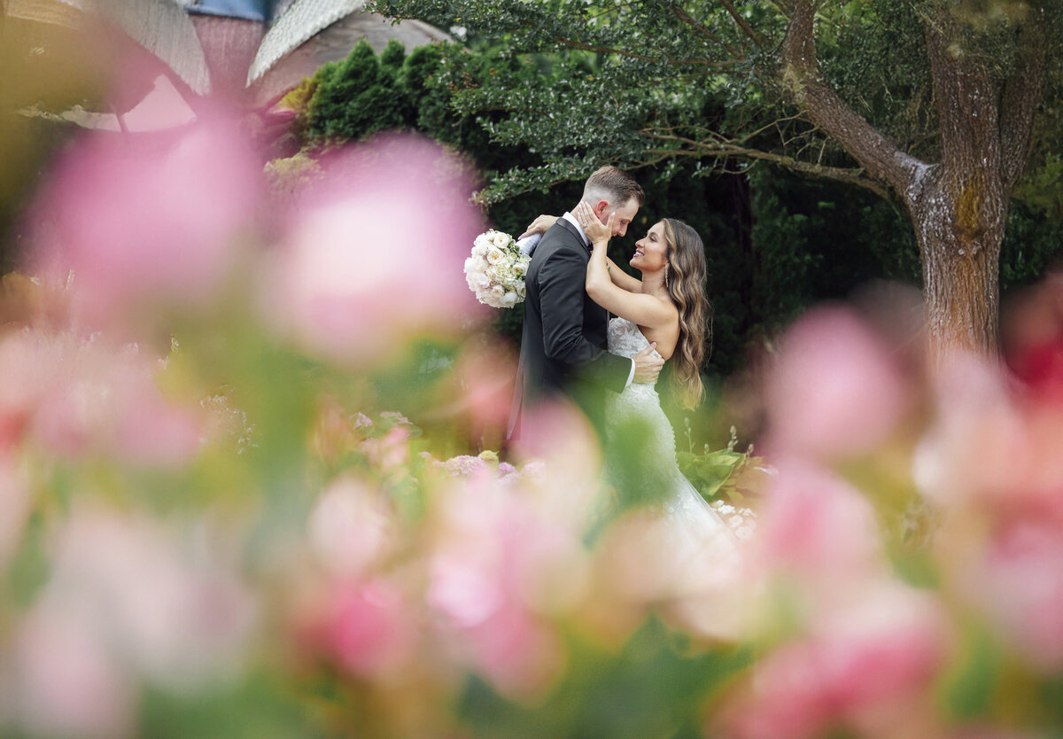 English Manor | Bride and groom hugging among spring flowers during wedding | Ocean Township, New Jersey