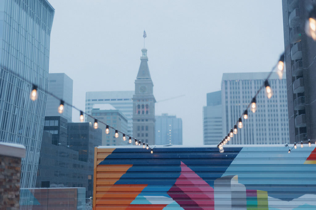 A brightly painted wall against a city skyline.