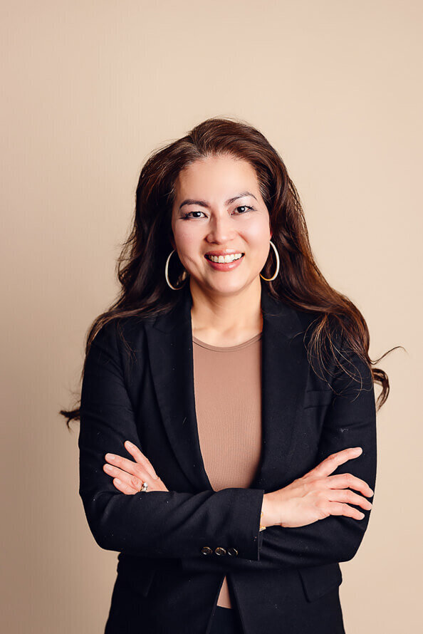 Woman folds arms and smiles.