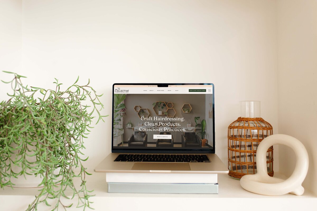 A laptop sits open and features a website design for an Eugene hair salon specializing in craft hairdressing, clean products, and conscious practices. 