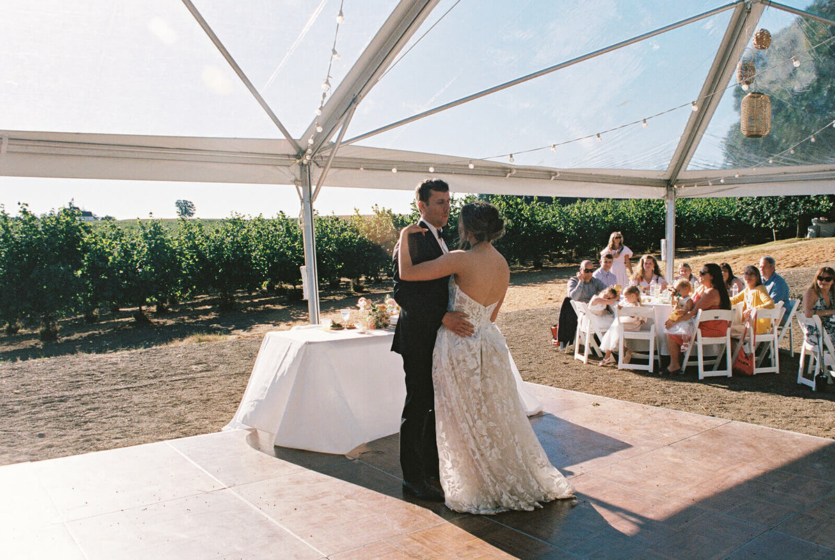 A bride and groom dance at a wedding reception.