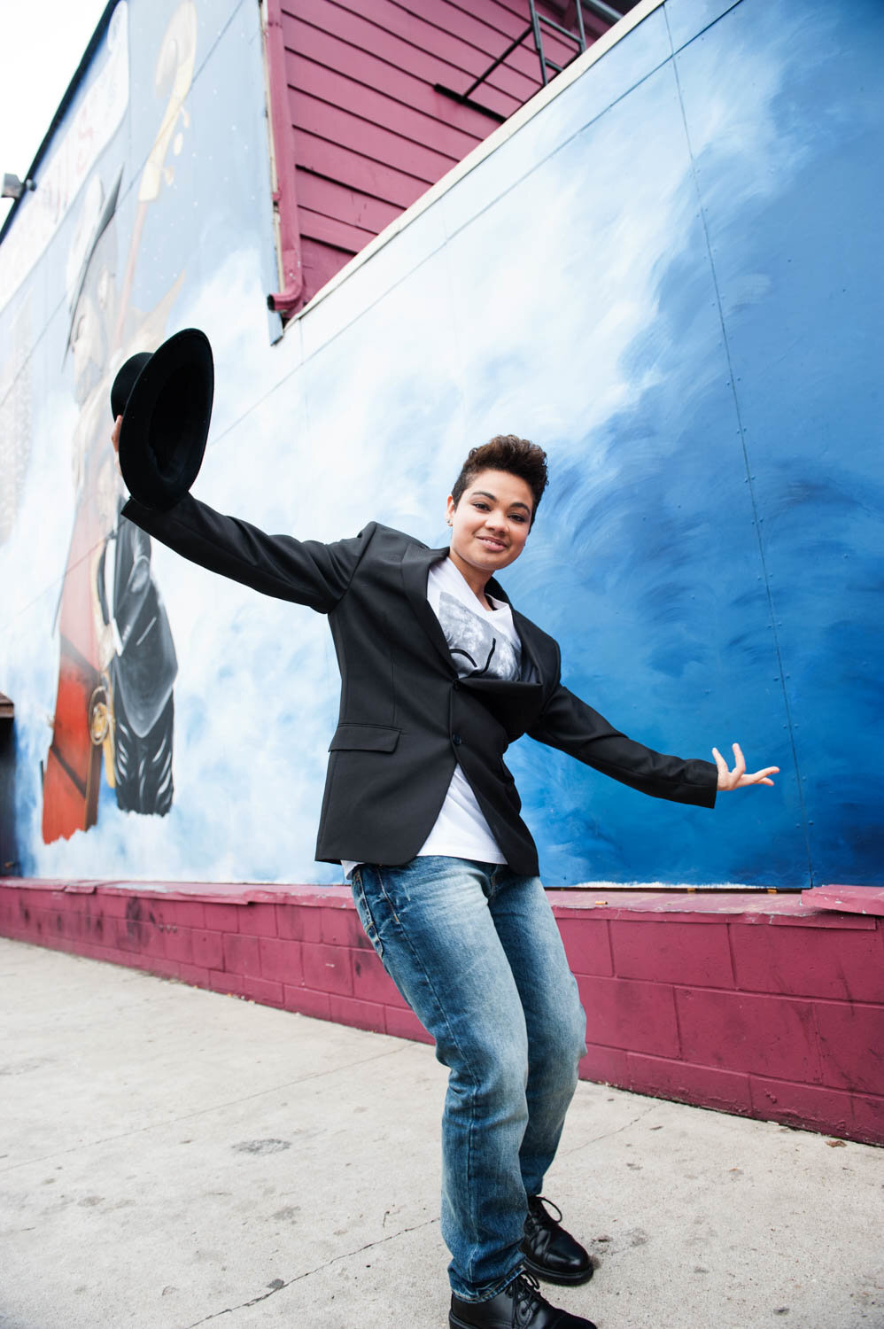 high school senior photo of urban style in front of mural