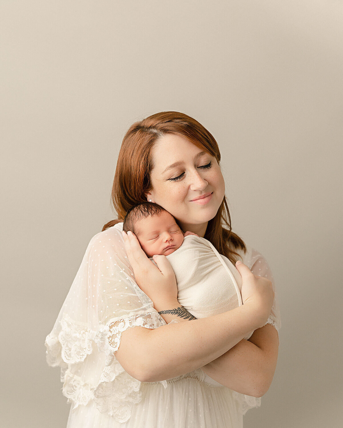 mom wearing lacy dress holding son for portland baby photography session in Ann Marshall's Studio