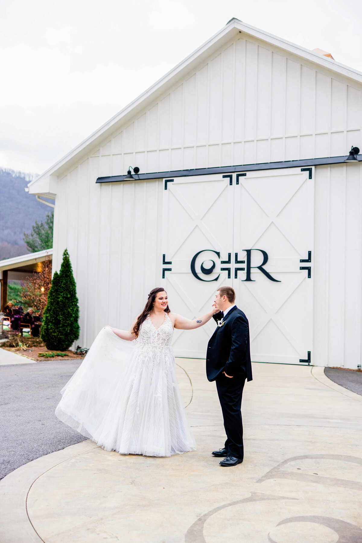 bride and groom dancing in front of barn