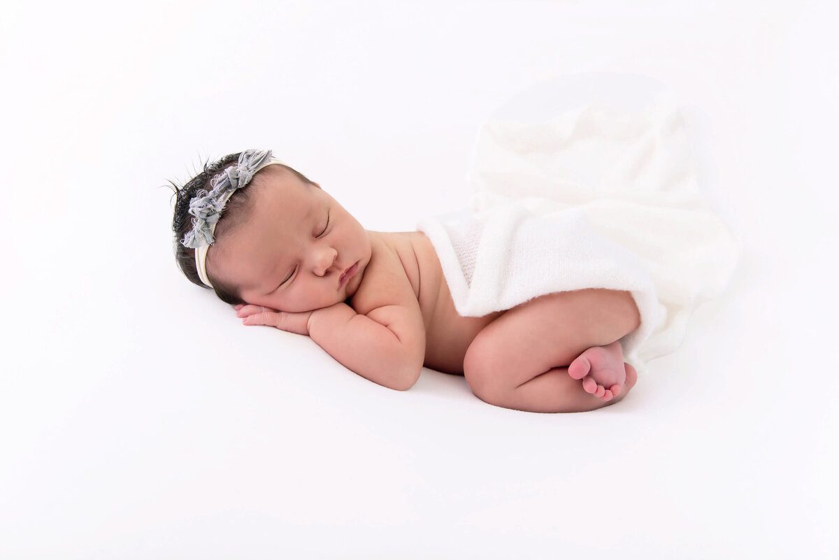 newborn girl on a white background for her newborn photos in Burlington, ON