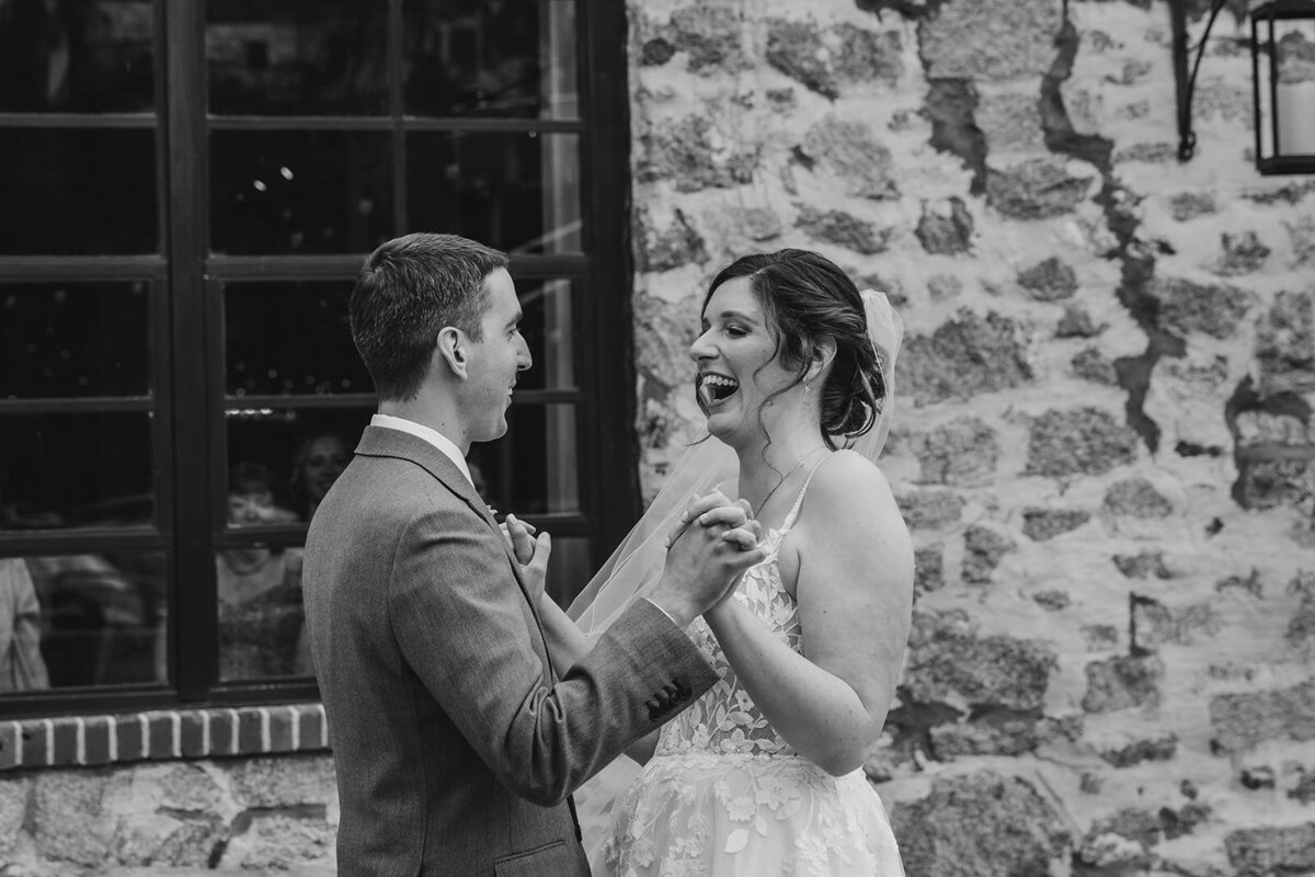 A newlywed couple laughing and holding hands 