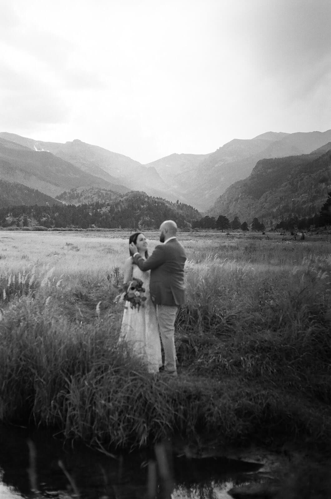 black and white film photo of couple with the mountains behind them