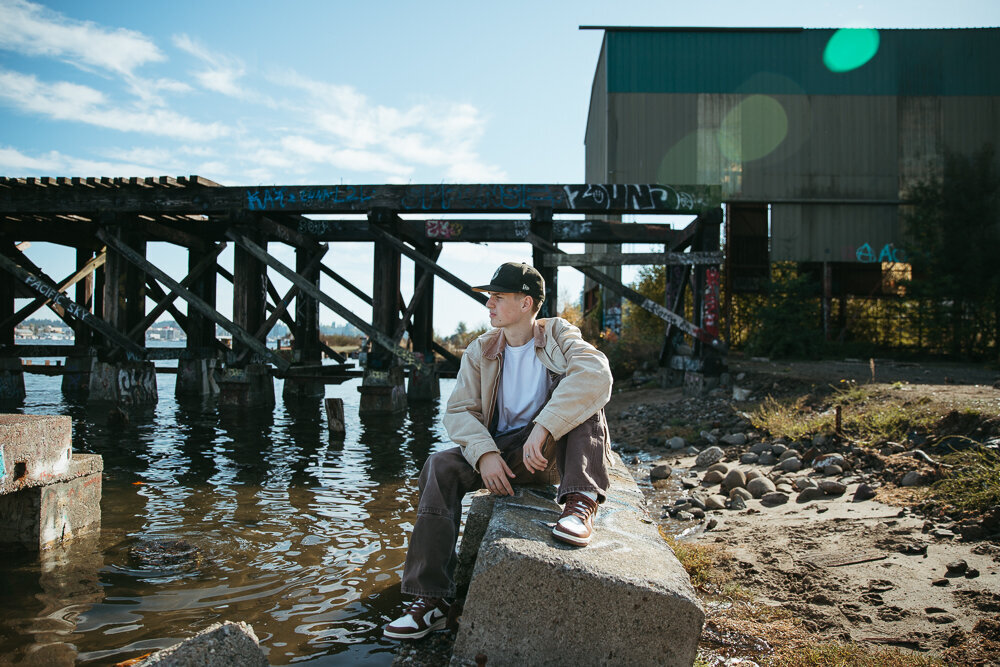 Boy posing for his senior pictures in Olympia WA by the water