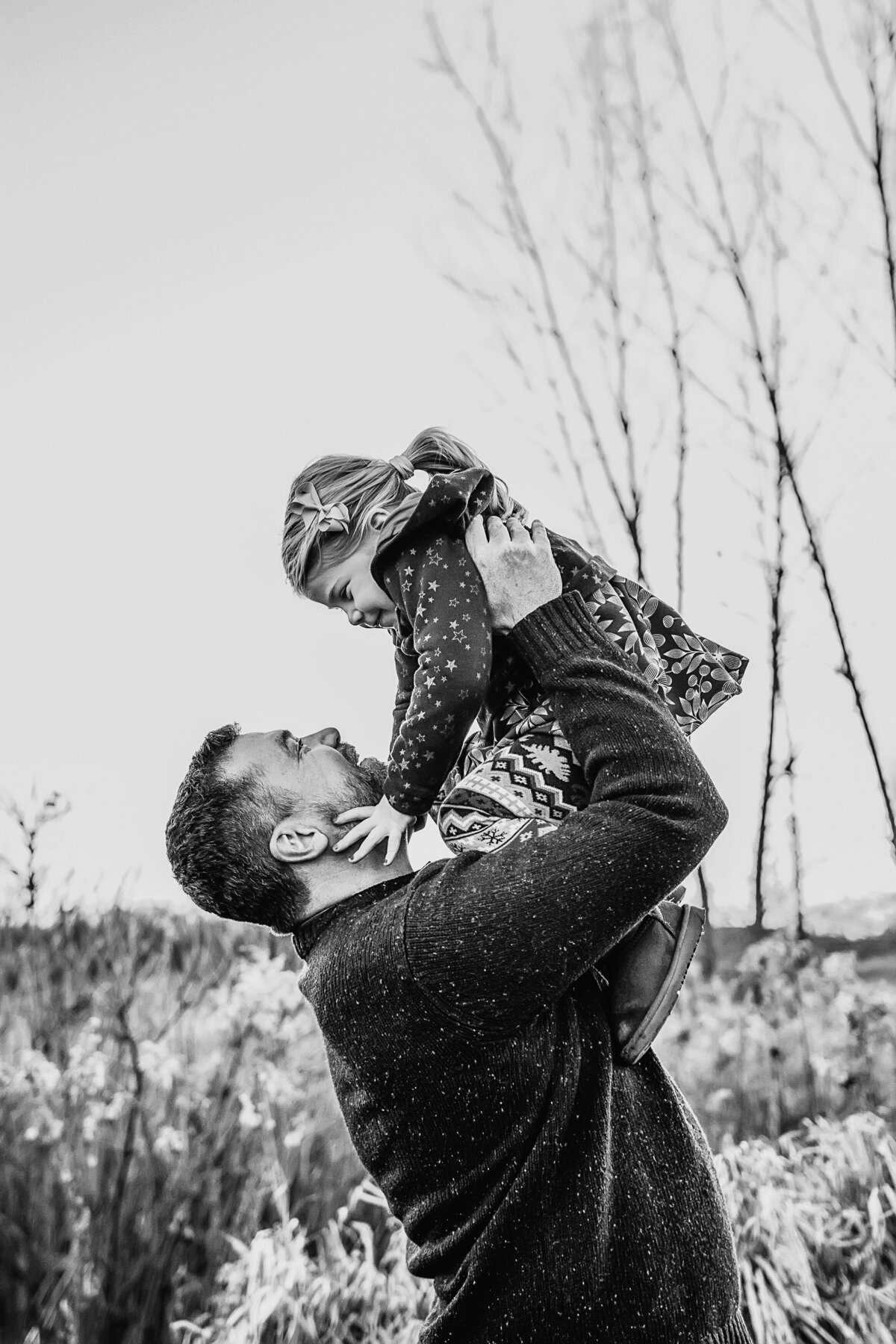 Lifestyle family photoshoot shot, with daughter's hands on dadd'y face.