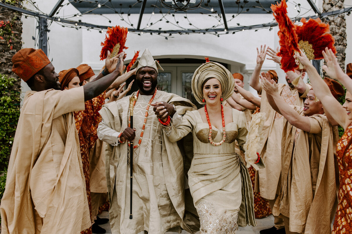 A couple smiles while everyone celebrates during their wedding exit.