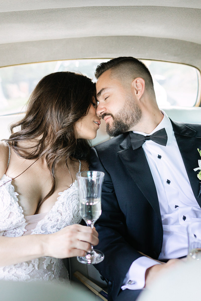 Un couple de nouveaux mariés s'embrasse dans une voiture antique