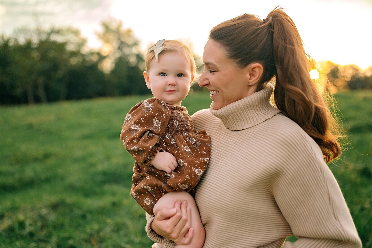 Mom and daughter smiling at sunset in a field in Harrisonburg VA