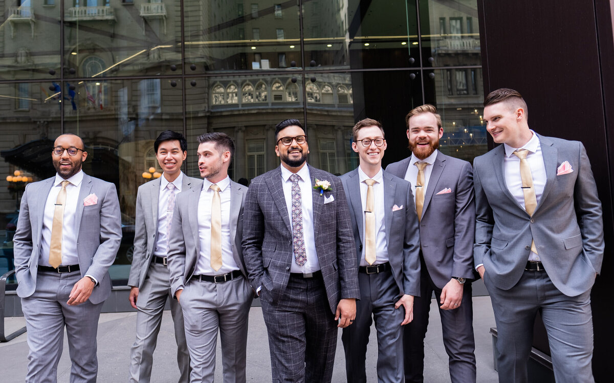 Groom-and-groomsmen-walking-downtown-calgary-fairmont-palliser-scaled