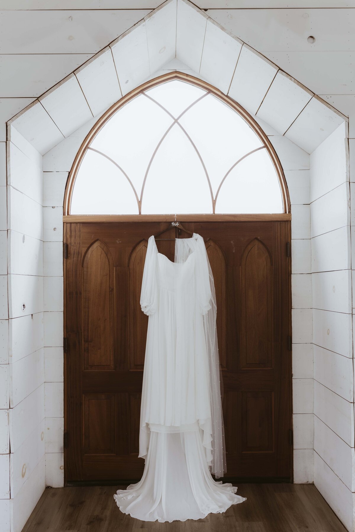 Brides dress hanging in wedding chapel entryway in Willard Missouri