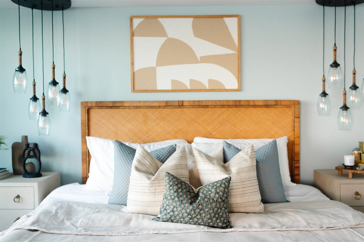 Bedroom with white and blue decorative pillows and a wooden headboard