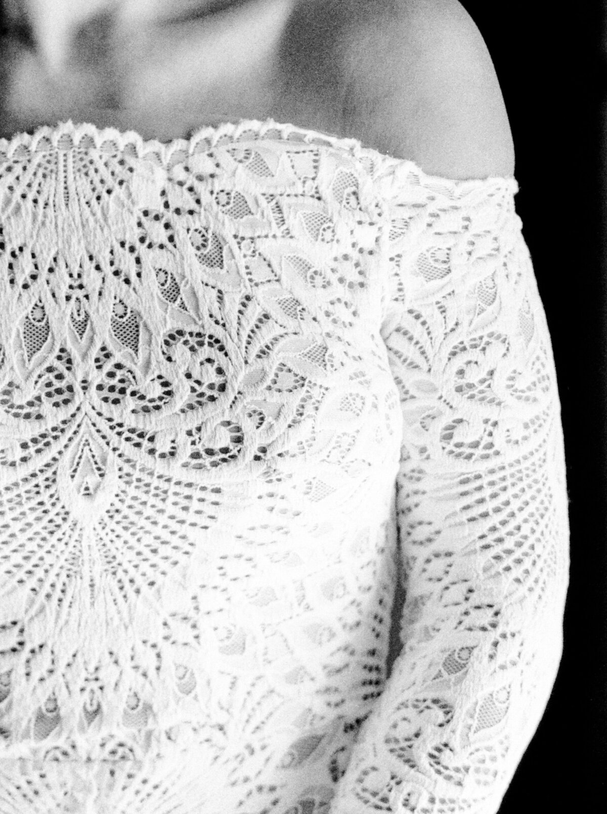 Black and white film photograph of bride in all lace long sleeved off the shoulder wedding gown photographed by Italy wedding photographer at Villa Montanare Tuscany wedding