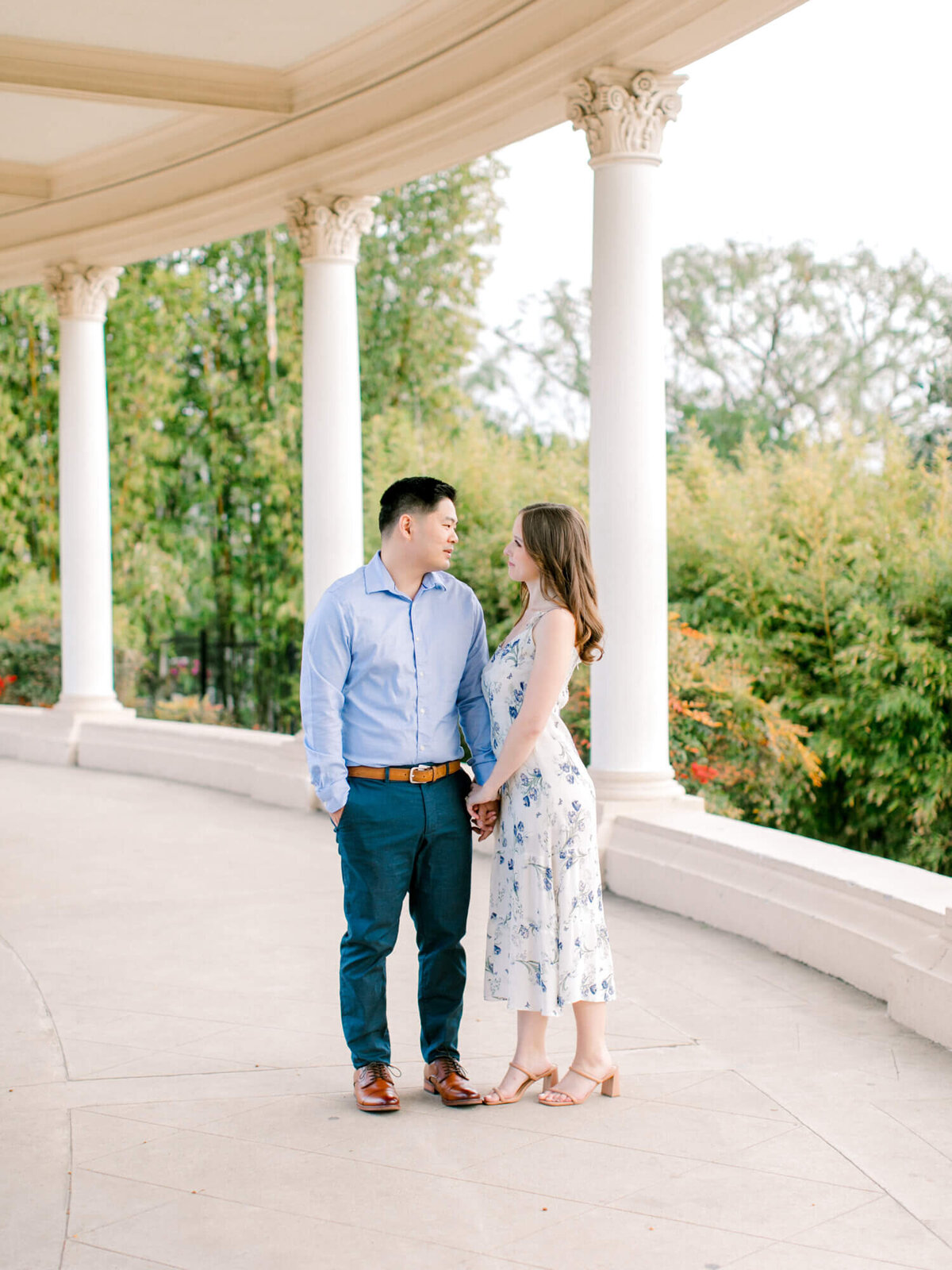 couple walking and looking at each other under the columns at balboa park