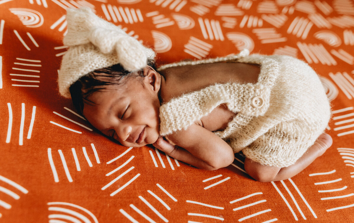 Infant photography session with newborn sleeping in a crib.