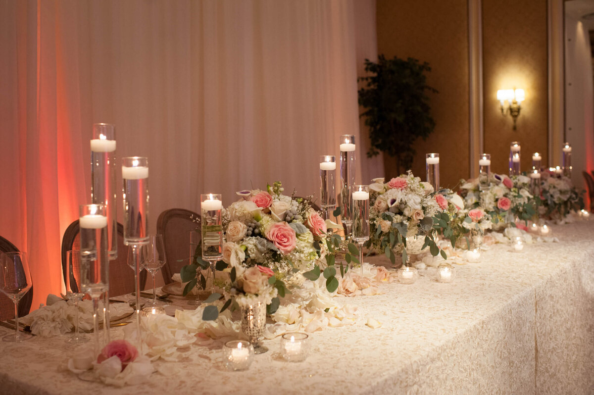 Spring flowers covering a long reception table at a high-end reception