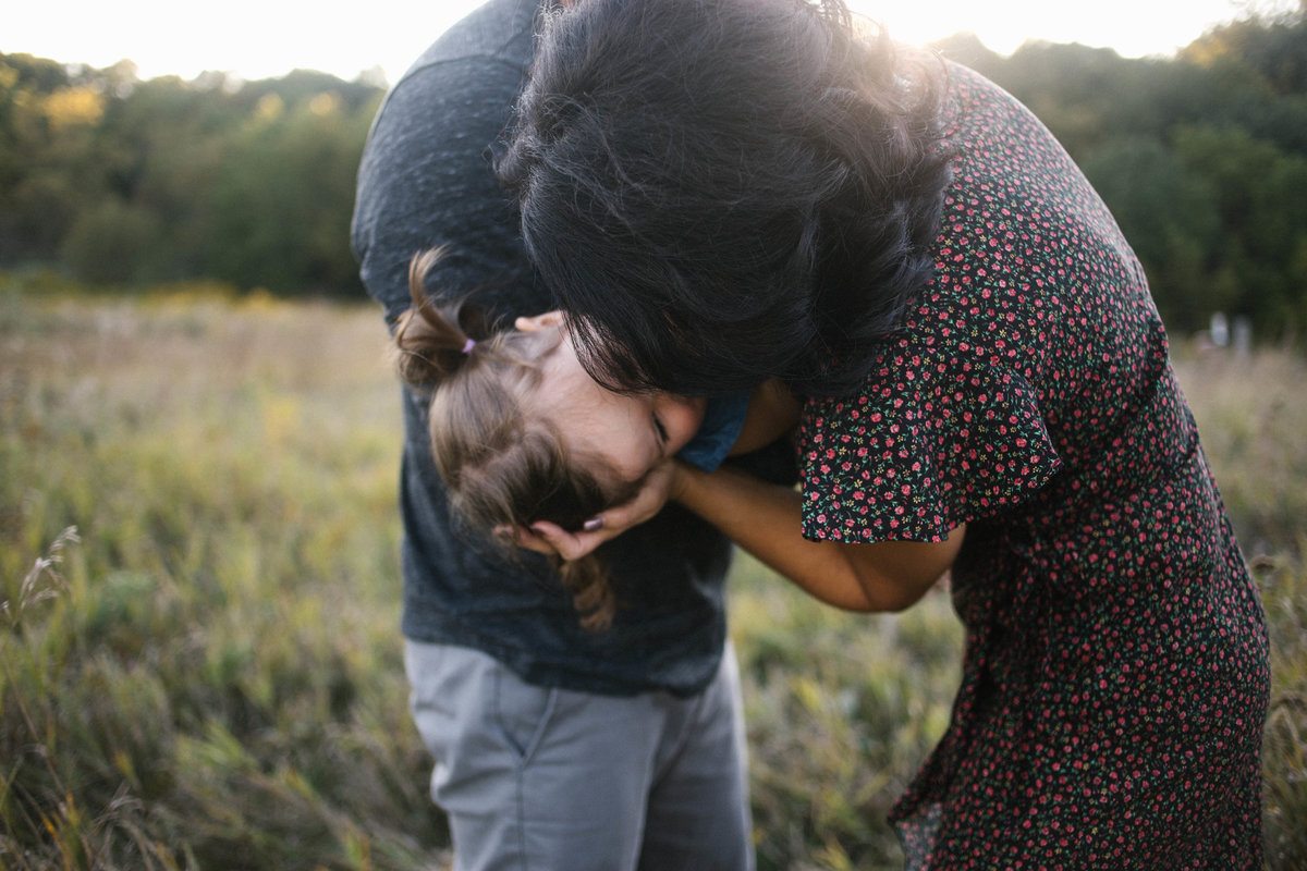 Mom and dad playing with daughter during outdoor photo session with Elle Baker Photography