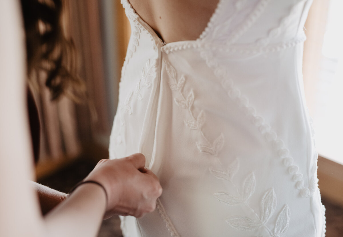 Photographers Jackson Hole capture bride's wedding dress getting zipped up