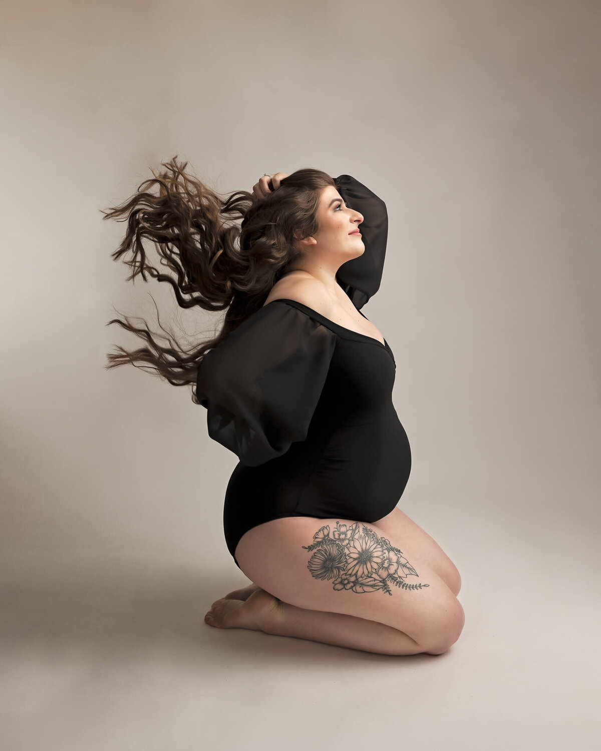 studio fine art Portland maternity photography of woman on knees throwing hair in studio maternity session