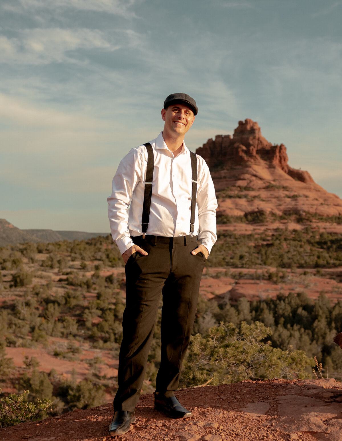 Couple standing against red rock backdrop during Sedona engagement session
