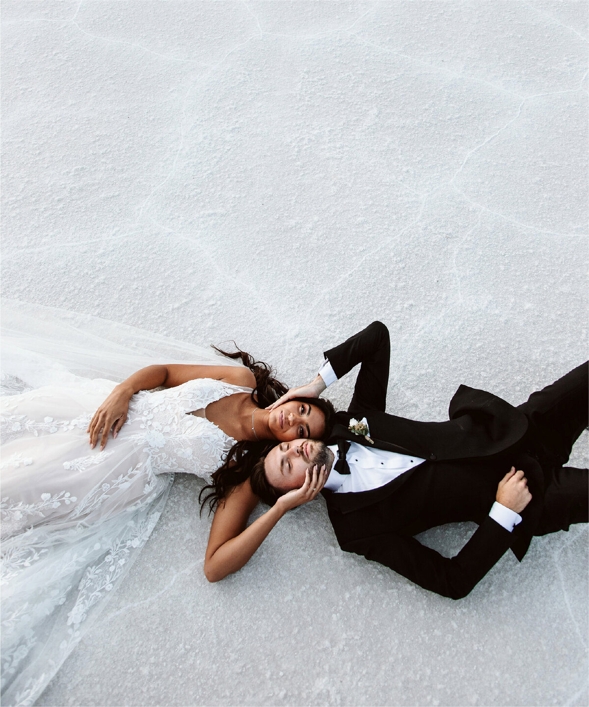 bride and groom on  white sand