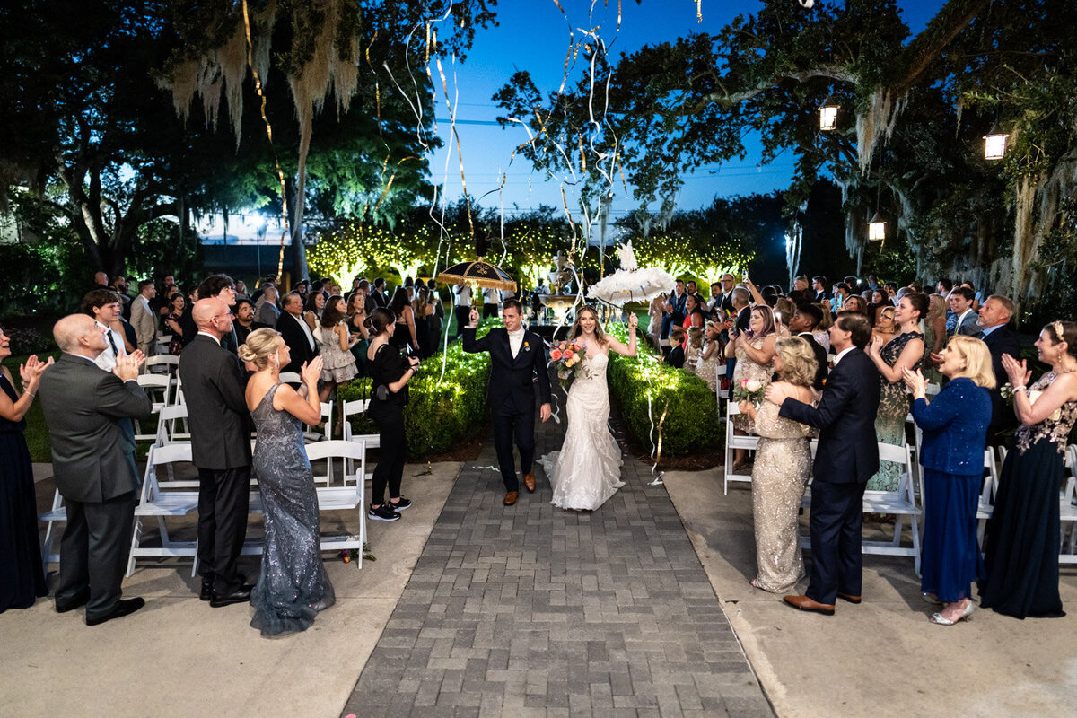 Bride and groom at end of Southern Oaks wedding ceremony with streamers
