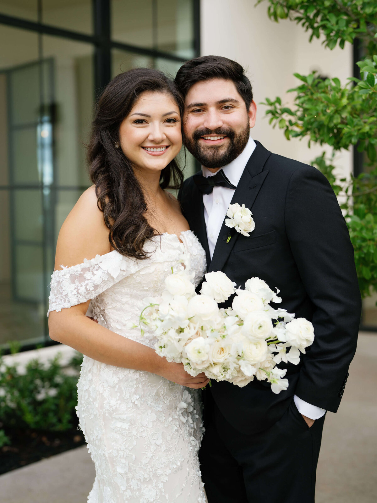 This timeless wedding day portrait showcases flawless bridal makeup, elegant curls, and a romantic lace gown styled by Mistique Makeup's bridal hair and makeup team in Austin. The groom’s polished look complements her radiant glow—perfect inspiration for couples seeking professional wedding day beauty services and men’s grooming.