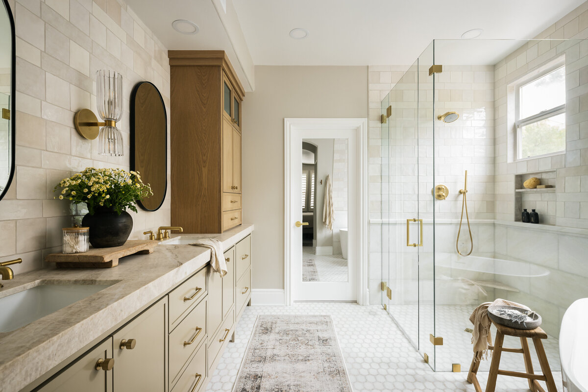 Master bath remodel with painted cabinets, white oak hutch, quartzite countertop, walk in shower, marble mosaic floor, marble and ceramic wall tile and brass plumbing fixtures