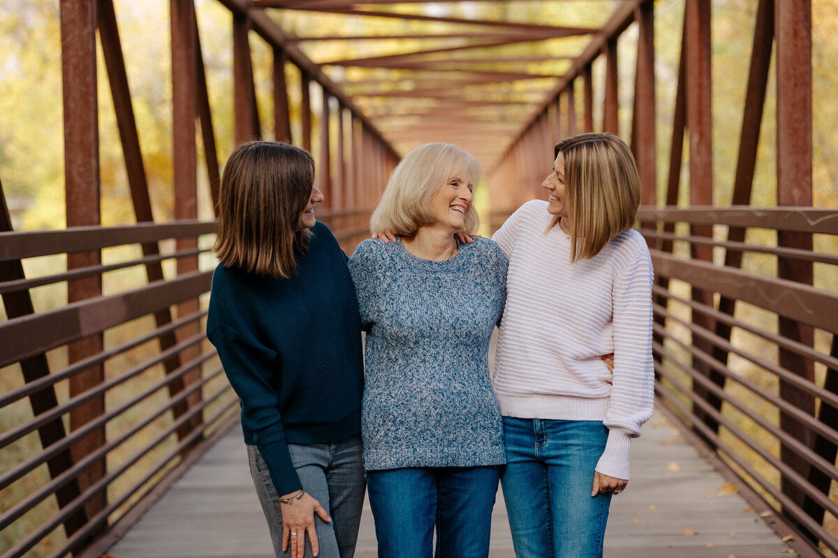 Two sisters pose with their mom during their fall family session in Fort Collins, Colorado