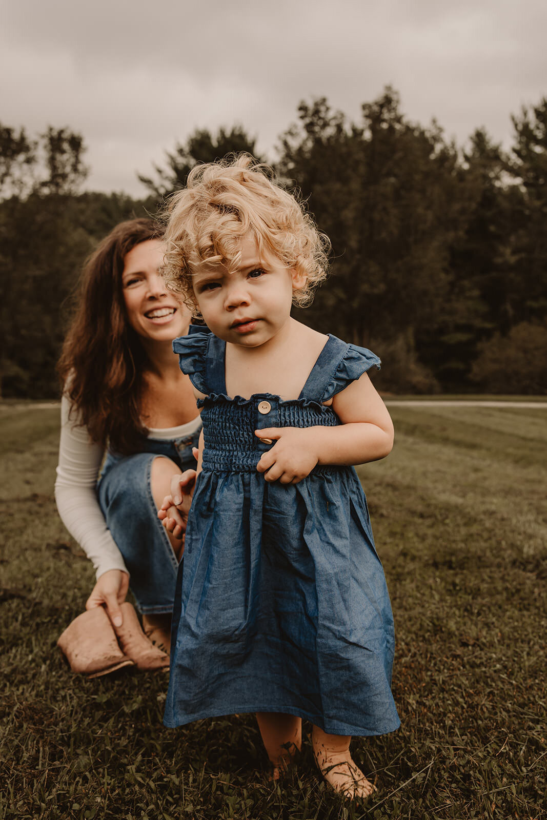 A child walking away from their parent in a field 