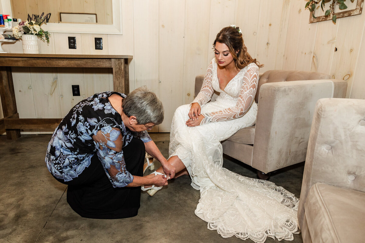 Mother of the bride buckling the brides high heels