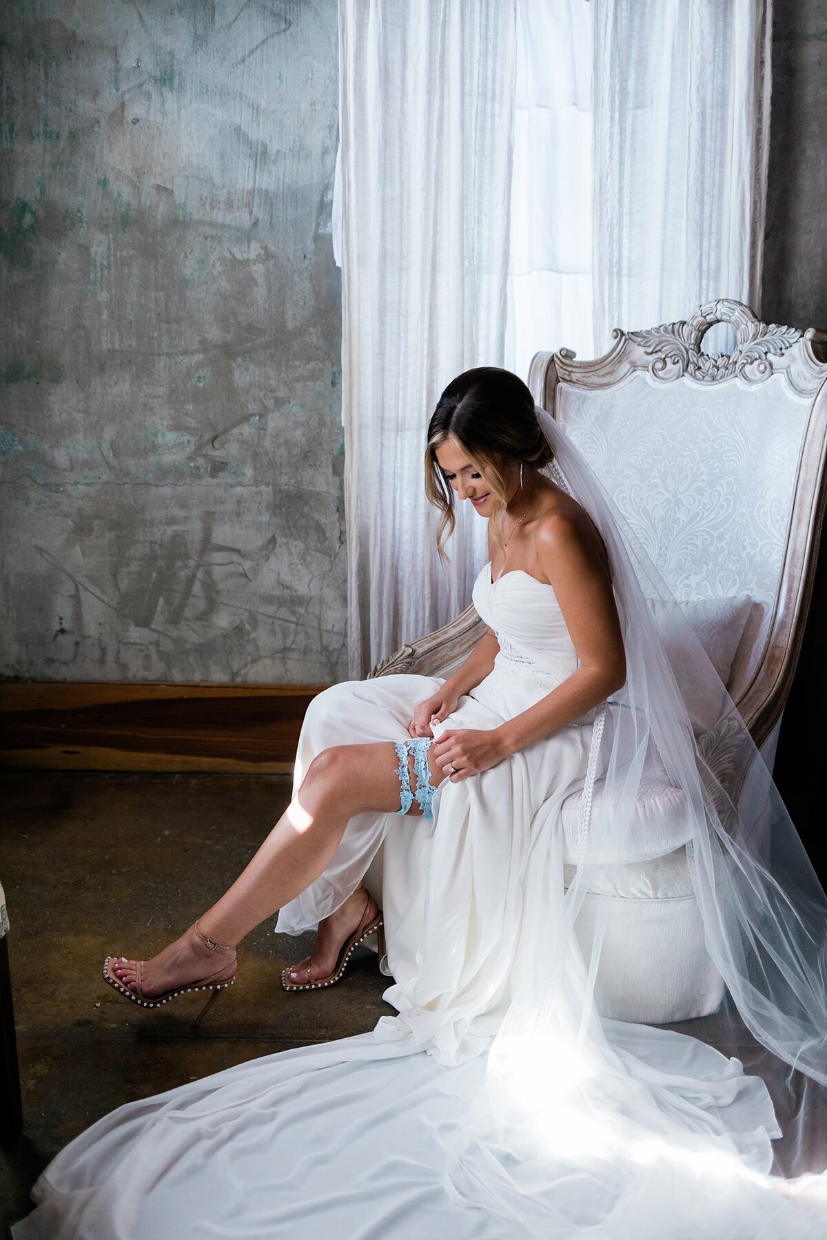 Bride putting on her garter in the bridal suite for her wedding at Olde Dobbin Station.