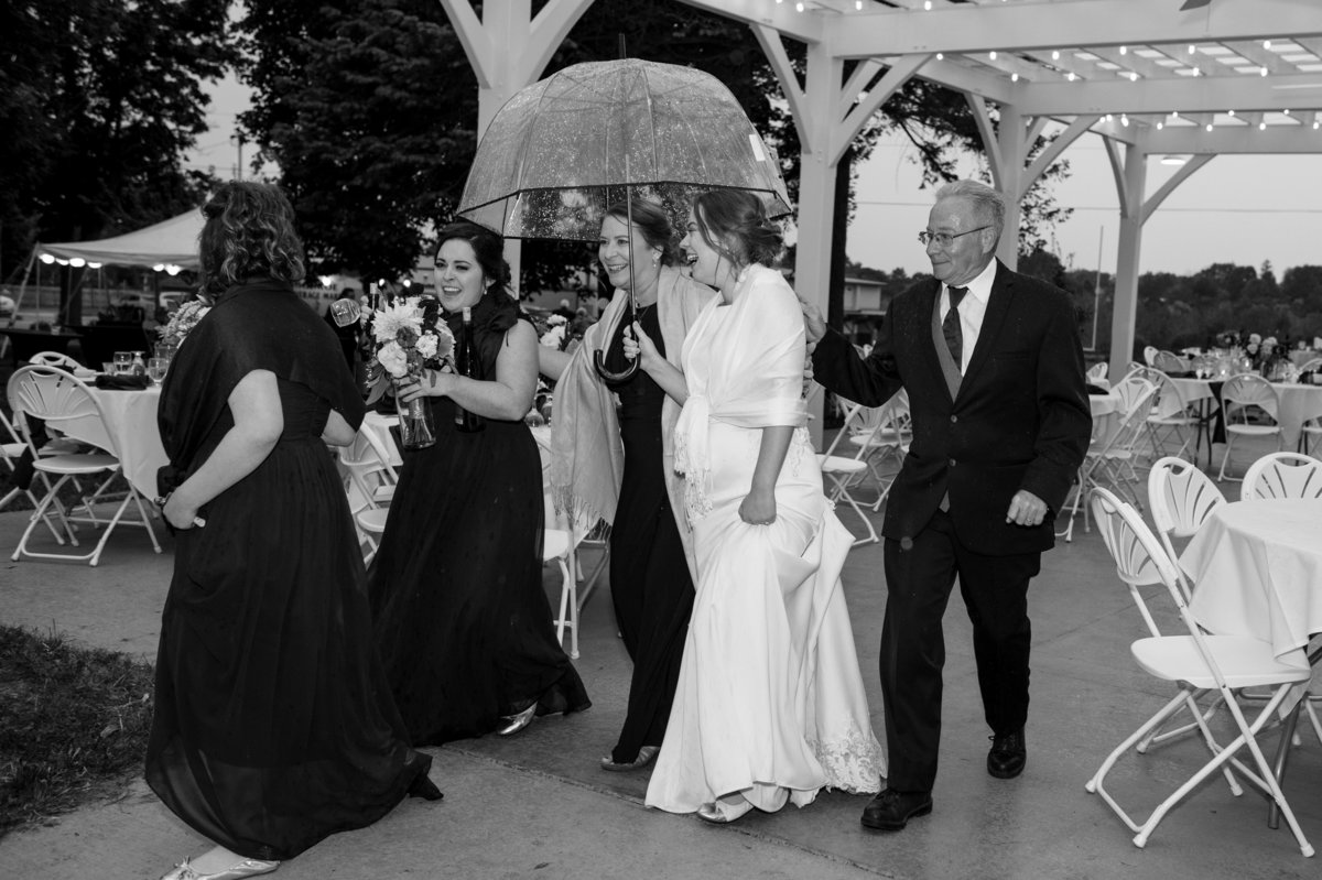 outdoor reception rained out bride under umbrella