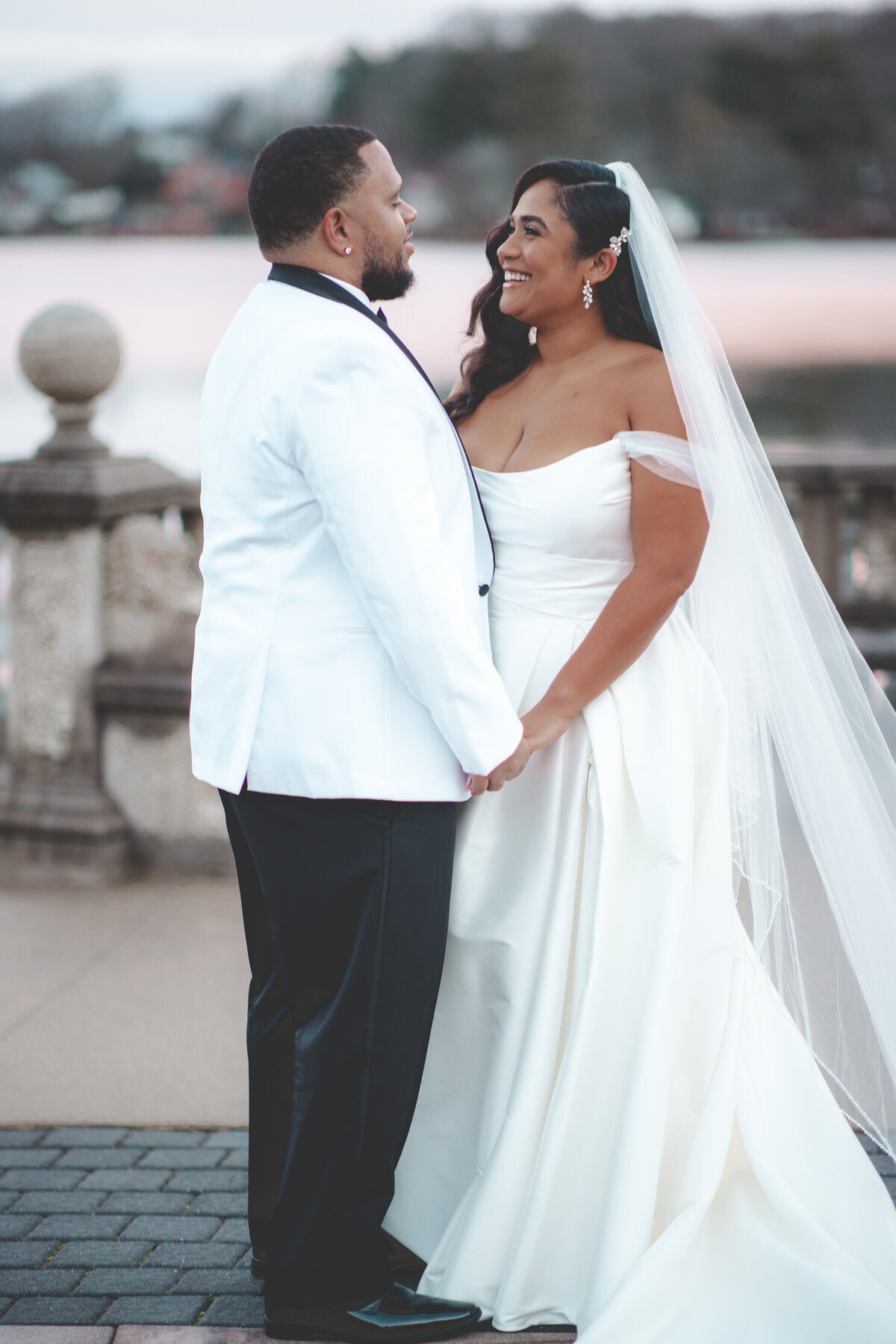 Bride and groom holding hands and smiling at each other