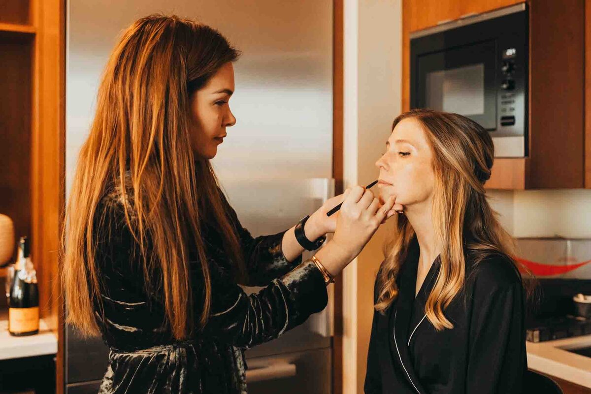jentry kelly puts on makeup for a bridesmaid