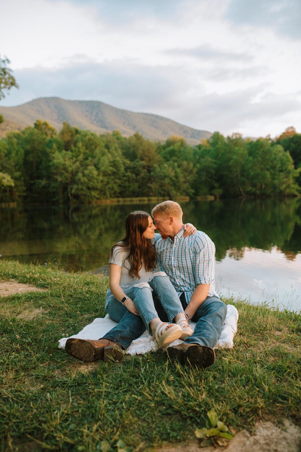 a couple sitting on the ground about to kiss