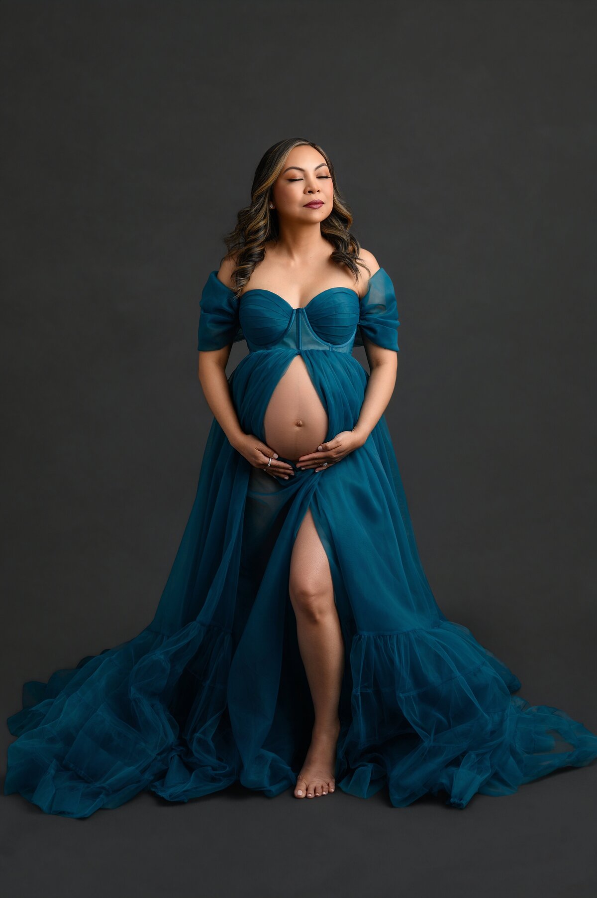 Indoor maternity glam session in West Palm Beach, Florida with elegant styling and dramatic lighting.