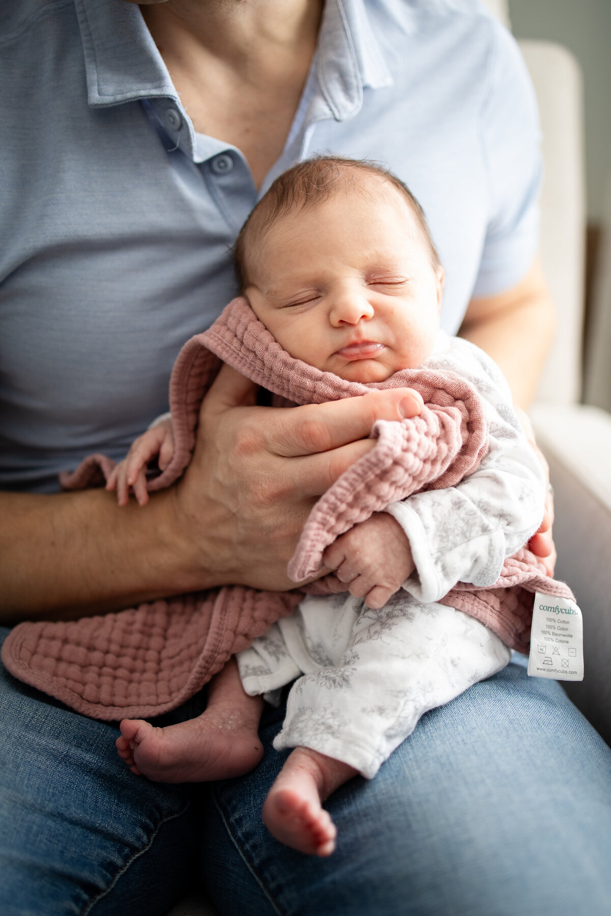 Newborn baby being burped by dad after a bottle