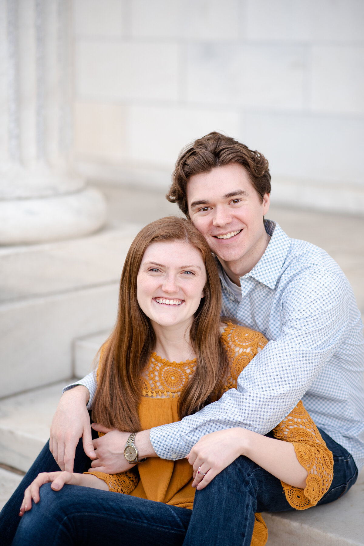 A smiling man and a smiling woman embracing while seated