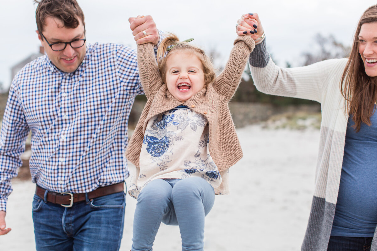 parents swinging daughter in the air