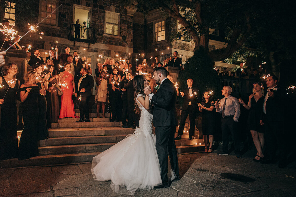 Glamorous bride and groom dancing during sparkler exit