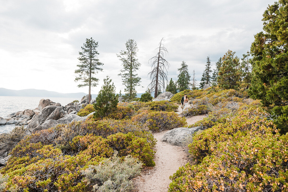 A couple embracing during their scenic elopement in Lake Tahoe, surrounded by crystal-clear waters and majestic mountains. This image, taken by a top California adventure wedding photographer, highlights the natural beauty and serene atmosphere of a Lake Tahoe elopement.