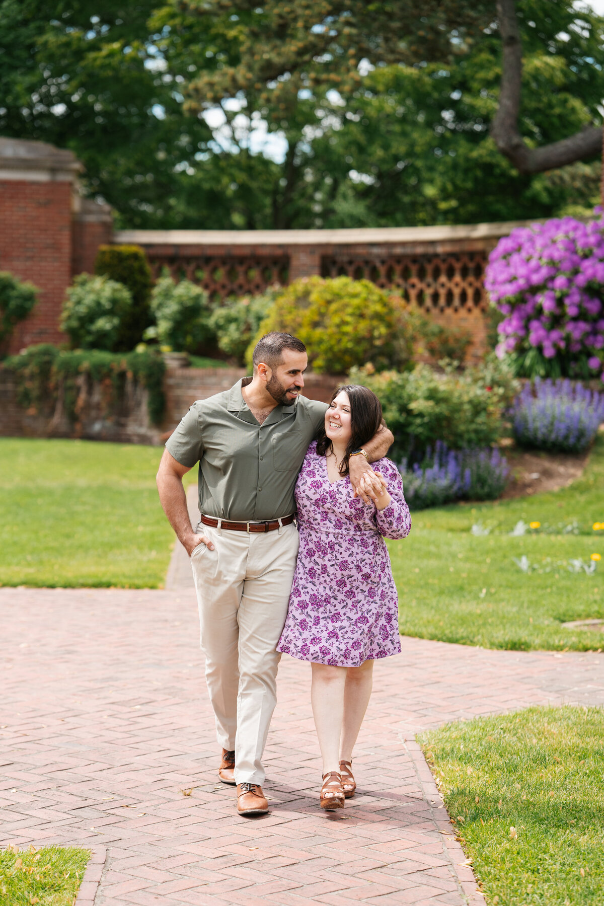 Couple walking through the rose garden at Lynch Park during their Beverly engagement session with Danielle Littles Photography